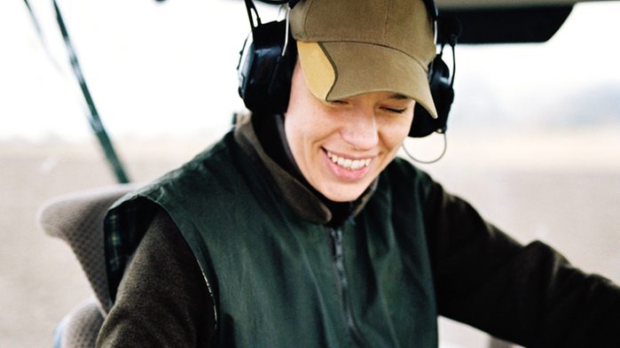 Närbild på ung kvinna som sitter i traktor.