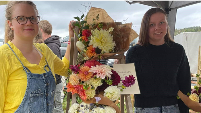 Emma Svensson och Sofia Warefelt bredvid ett blomsterarrangemang.