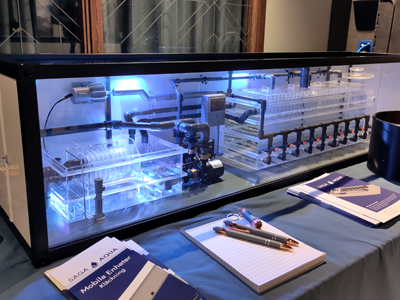 Container i miniatyr innehållande olika genomskinliga plastkärl och rör.