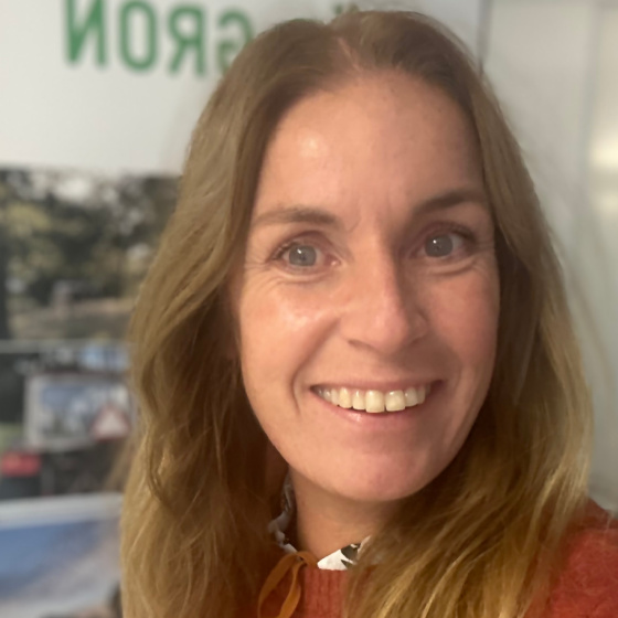 Anna Ross har långt hår och röd överdel