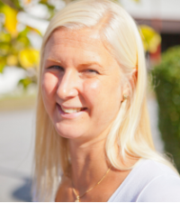 Rebecca Källström har blont hår och sitter ute i solskenet