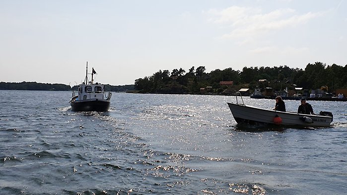 Fiskebåt och motorbåt på sjön