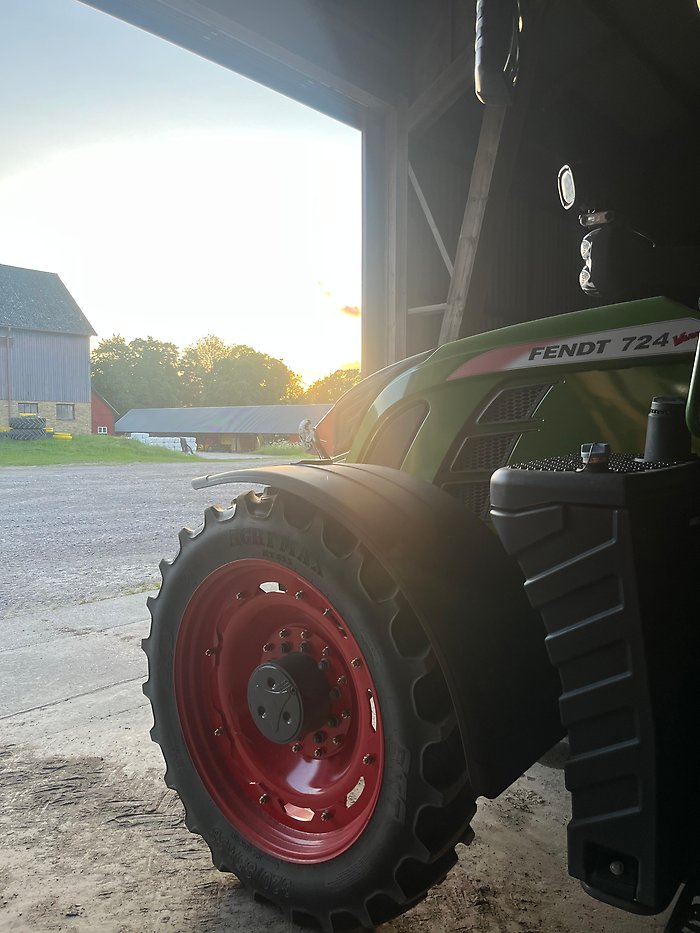 Traktor åker ut i gryningen vid ladugården