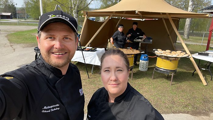 Rickard Backskog och Ann Sparrock på Torsta offentlig gastronomi. Bakom dem syns ett tält där det pågår utematlagning.