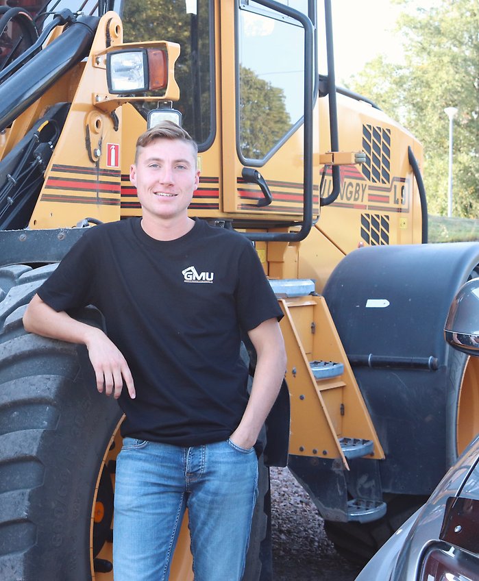 Henning Griph står vi en gul traktor på sin gård